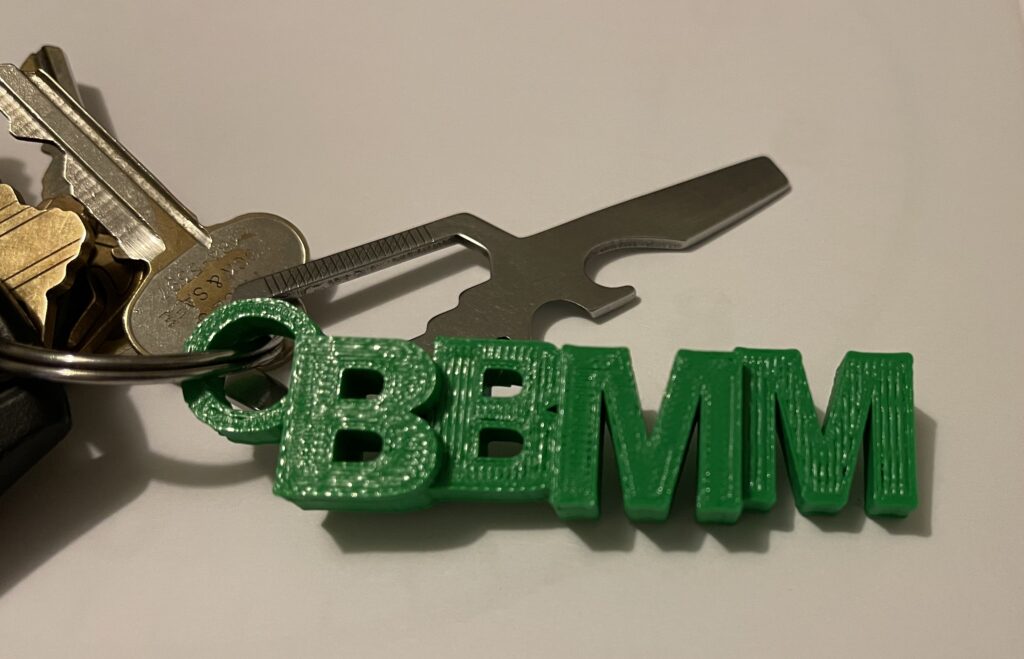 Set of keys with a green 3D-printed keychain with the letters BBMM